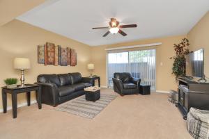 a living room with leather furniture and a ceiling fan at The Cure Lounge in Houston