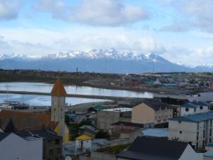 a city with snow covered mountains in the background at La Vela in Ushuaia