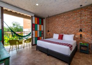 1 dormitorio con cama y pared de ladrillo en NQ Hotel Orinoquia, en Villavicencio