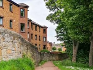 a stone wall in front of a brick building at The Kyles 