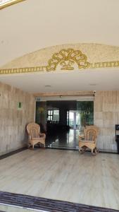 a lobby with two chairs and a ceiling at Hotel Dorado Barranquilla in Barranquilla