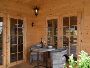 eine Terrasse mit einem Tisch und Stühlen in einer Hütte in der Unterkunft Pinewood Cabin in Saline