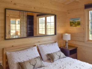 a bedroom with a bed with a mirror above it at Pinewood Cabin in Saline