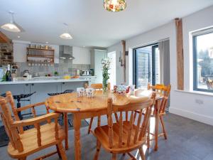 a kitchen and dining room with a wooden table and chairs at The Woodshed in Sheepwash