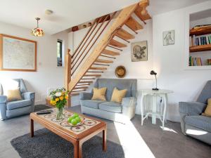 a living room with two chairs and a table at The Woodshed in Sheepwash