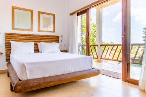 um quarto com uma cama e uma varanda em CasaLô Hotel em Jericoacoara