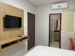 a bedroom with a tv on a wall with a bed at Mauri Center Hotel in Picos