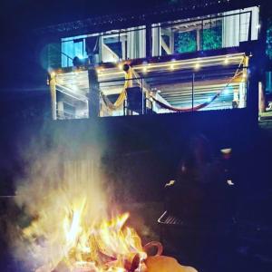 a person sitting over a fire in a grill at Igarata Cabana da Sol in Igaratá