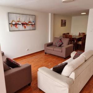 Sala de estar con 2 sofás y mesa en Apart Hotel Cabral, en Lima