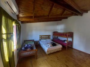 um quarto com 2 camas e piso em madeira em Cabañas Marian 2 em Puerto Iguazú