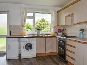 uma cozinha com uma máquina de lavar roupa e uma janela em Haweswater Cottage em Coundon