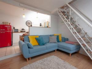 ein Wohnzimmer mit einem blauen Sofa und einer Treppe in der Unterkunft Bird Box in Brixham