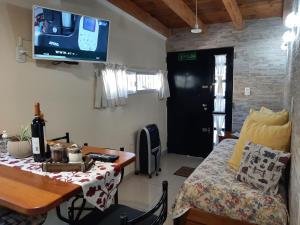 Habitación con cama, mesa y TV. en M & Mendoza en Mendoza