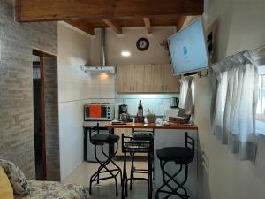 M & Mendoza في ميندوزا: مطبخ صغير مع كونتر وكراسي في الغرفة