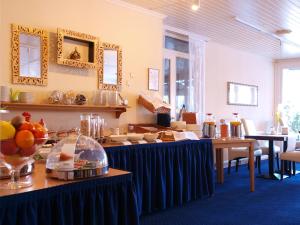 une salle à manger avec des tables et des assiettes de nourriture dans l'établissement Park Hotel, à Bad Zwischenahn