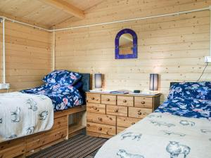 a bedroom with two beds and a wooden wall at Moonlight View - Uk35187 in Newtown
