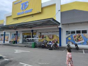 a woman standing in front of a pizza store at Rumah Singgah in Pantai Remis