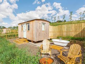 a small wooden shed with a sink and two chairs at Woodside Hut 2 - Uk36106 in Auchterneed