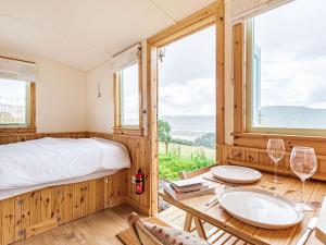 a bedroom with a bed and a table with two wine glasses at Woodside Hut 2 - Uk36106 in Auchterneed