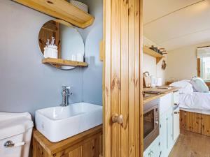 a small kitchen with a sink and a bed at Woodside Hut 2 - Uk36106 in Auchterneed