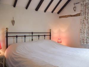 a bedroom with a white bed with two lamps at Pentre Cwm Bach in Llansilin