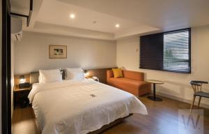 1 dormitorio con 1 cama blanca grande y 1 silla en Number 25 Hotel Gimhae Eobang en Gimhae