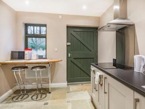 a green door in a kitchen with a counter and stools at Annex 2 - Uk35340 in Ranskill