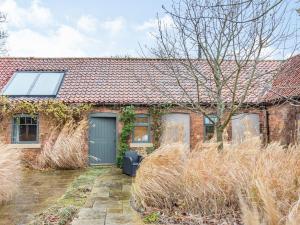 an old brick house with a blue garage at Annex 2 - Uk35340 in Ranskill