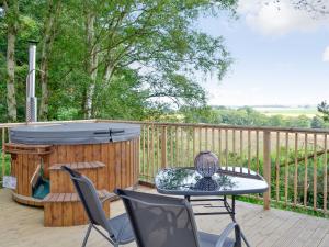 a deck with a hot tub and a table and chairs at Goose View in Montrose