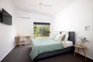 a bedroom with a bed and a window at The Atrium in Shoal Bay