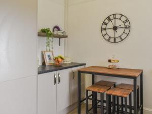 a kitchen with a table and a clock on the wall at Britannic Chambers Apartment in Blaenau-Ffestiniog