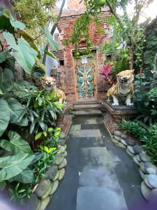 a garden with two tigers in front of a door at Rahayu Guest House Seminyak in Seminyak