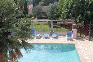 a swimming pool with chairs and a gazebo at Chambres d'hôtes Le Clos des Oliviers in Sorbo-Ocagnano