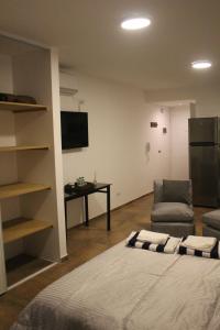 Habitación con cama, silla y escritorio. en AA Naon apart en Buenos Aires