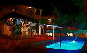 una piscina frente a una casa por la noche en GR Stays WHITE HOUSE 4bhk Private Pool Villa in Calangute en Calangute