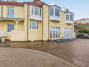 a large yellow house with a parking lot at The Bath House in Cromer