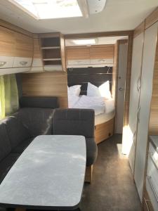 a small room with a couch and a bed at Wohnwagenvermietung CAMPING-SYLT / Morsum in Westerwall