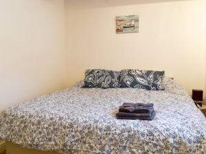 a bedroom with a bed with a blue and white comforter at Barn 2 in Ulverston