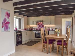 a kitchen with a wooden table and chairs at Furzy Cottage in Haverfordwest