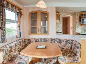 a living room with a couch and a table at Methlem Chalet in Aberdaron