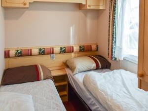 a small room with two beds in it at Methlem Chalet in Aberdaron