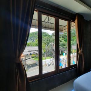 ventana del dormitorio con vistas a un parque infantil en Namu Hotel, en Pai