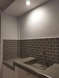 La salle de bains est pourvue d'un lavabo et d'un mur en briques. dans l'établissement YUMIYAMI FARM AND RESORT, 