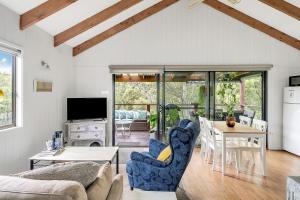 a living room with a table and chairs at Refreshing Rainforest Retreat Kangaroo Valley in Kangaroo Valley