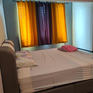 a bed in a room with two windows at HAPPY STAY MOTEL in Jitra +16 photos