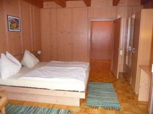 ein Schlafzimmer mit einem weißen Bett in einem Zimmer in der Unterkunft Enzianhof in Ligist