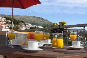 uma mesa de madeira com copos de sumo de laranja em Green Park Apartments em Dubrovnik