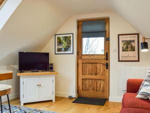 a living room with a tv and a door at Loftings in Hendred
