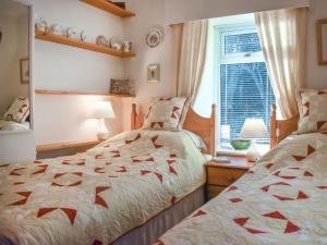 a bedroom with two beds and a window at Woodside in Cloughton