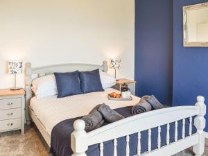 - une chambre avec un lit blanc aux murs bleus dans l'établissement Bryn Derwen, à Llanfair